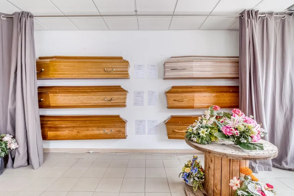 Modèles de cercueils en bois exposés dans une agence funéraire.